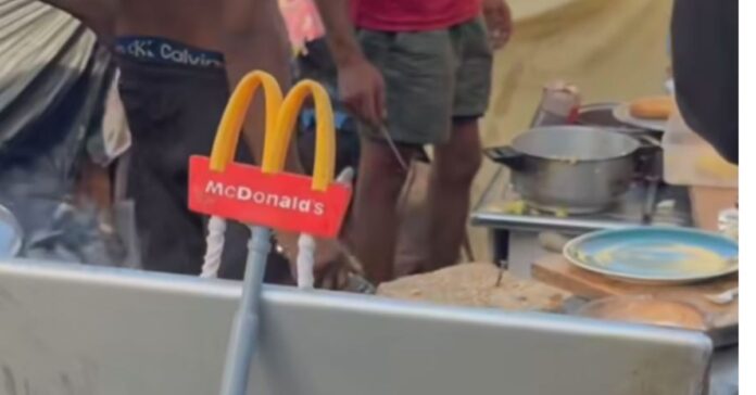 Los migrantes asentados en la playa del Trampolín crean su propio «McDonald’s» en un poblado improvisado